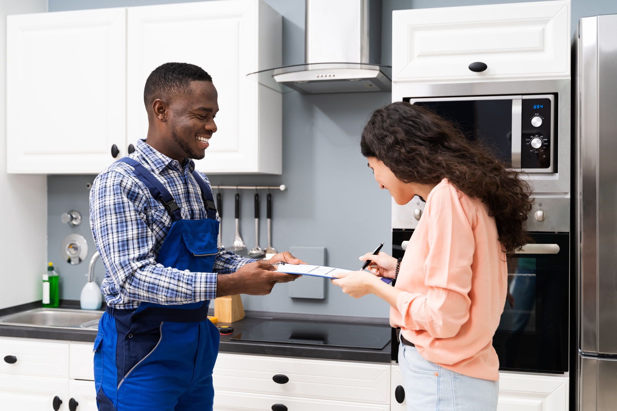 Smiling Customer Woman Signing Appliance Repair Invoice